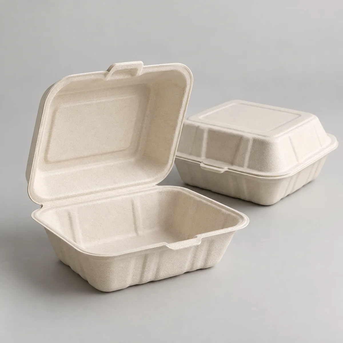 Natural molded-fiber clamshell takeaway containers shown open and closed